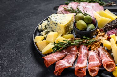 Prosciutto, jambon, peynir ve zeytinli tipik İtalyan antipasto. Siyah arka plan. Üst Manzara. Metin için boşluk