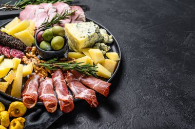 Prosciutto, jambon, peynir ve zeytinli tipik İtalyan antipasto. Siyah arka plan. Üst Manzara. Metin için boşluk