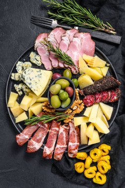 Prosciutto, jambon, peynir ve zeytinli tipik İtalyan antipasto. Siyah arka plan. Üst görünüm