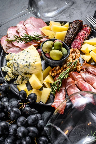 Typisch italienische Antipasti mit Schinken, Schinken, Käse und Oliven. Schwarzer Hintergrund. Ansicht von oben — Stockfoto