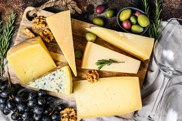 Coleção de queijos suíços, holandeses, franceses, italianos com nozes e uvas. Fundo escuro. Vista superior — Fotografia de Stock