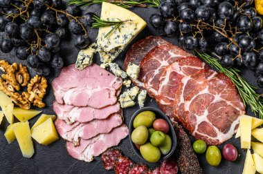 Prosciutto, jambon, peynir ve zeytinli tipik İtalyan antipasto. Siyah arka plan. Üst görünüm