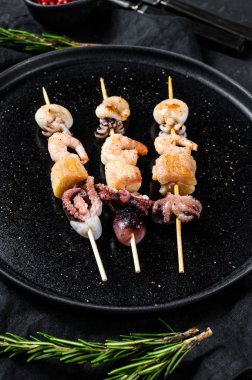 Deniz ürünleriyle barbekü. Tahta şiş kebap, karides, ahtapot.