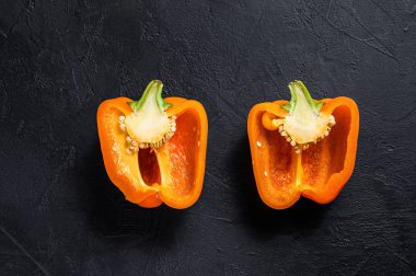 Portakallı dolma biber, iki yarım. Siyah arka plan. Üst Manzara. Metin için boşluk.