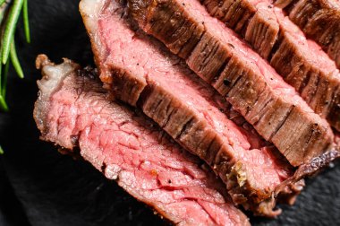 Dilimlenmiş bifteğin orta pişmiş hali. Siyah arka plan. Üst görünüm