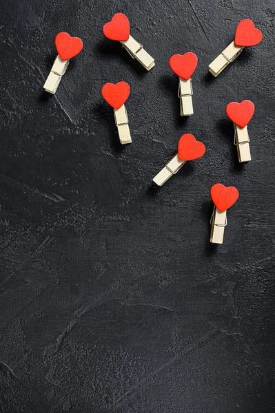Valentijnsdag concept. Rode harten en wasknijpers. zwarte achtergrond. Bovenaanzicht. Ruimte voor tekst — Stockfoto