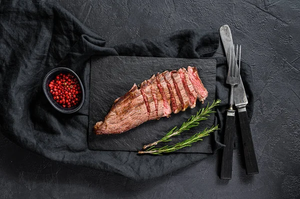 Biftek Lokantası Menüsü - Siyah taştan bir panoda biftekli biftek. Siyah arka plan. Üst görünüm