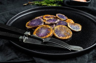 Biberiyeli kızarmış mor patates. Siyah arka plan. Üst görünüm
