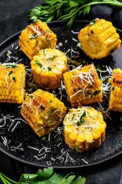 Parmesan ve maydanozla kızartılmış mısır. Organik çiftlik sebzeleri. Siyah arka plan. Üst görünüm
