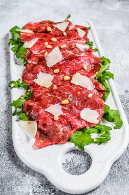Parmesan peynirli siyah angus bifteği carpaccio. Gri arka plan. Üst görünüm