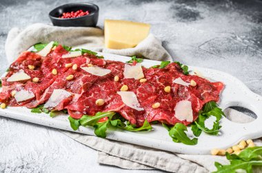 Mermer etli Carpaccio. Çiğ et, siyah Angus. Gri arka plan. Üst görünüm