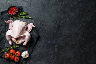 Biberiyeli ve pembe biberli çiğ tavuk. Siyah arka plan. Üst Manzara. Metin için boşluk