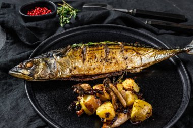 Fırında patates ve mantarlı ızgara uskumru. Siyah arka plan. Üst görünüm