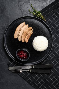 İştah açıcı kızarmış kabuklu ızgara hindi bifteği fileto. Haşlanmış pirinçli garnitür. Siyah arka plan. Üst Manzara. Metin için boşluk