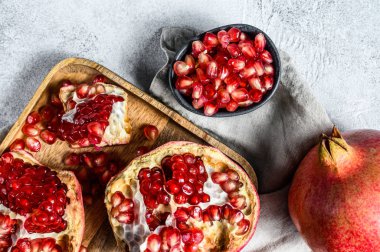 Tahta bir kasede taze, olgun bir nar. Organik meyve. Gri arka plan. Üst görünüm