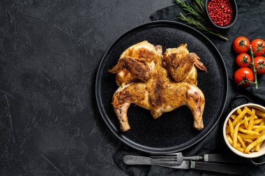 Bitki ve sarımsaklı kızarmış tavuk tütünü. Siyah arka plan. Üst Manzara. Metin için boşluk