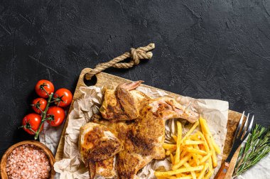 Bitki ve sarımsaklı kızarmış tavuk tütünü. Siyah arka plan. Üst Manzara. Metin için boşluk