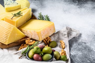 Üzüm, kraker, zeytin ve fındık ile servis edilen peynir tabağı. Çeşit çeşit lezzetli atıştırmalıklar. Gri arka plan. Üst Manzara. Metin için boşluk