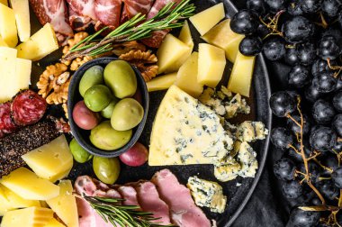 Prosciutto, jambon, peynir ve zeytinli tipik İtalyan antipasto. Siyah arka plan. Üst görünüm
