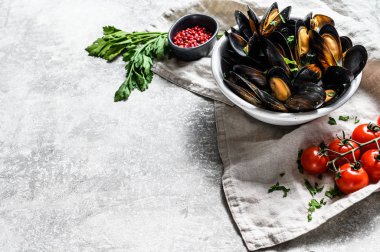 Otlu midyeler ve kabın içinde sos. Gri arka plan. Üst Manzara. Metin için boşluk