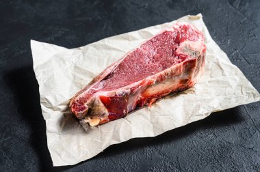 Kemiğe sığır eti, sığır filetosu. Siyah arka plan. Üst görünüm