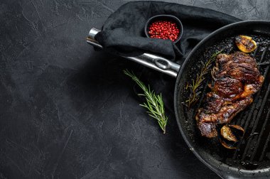 Izgara tepsisinde biftek. Biftek. Siyah arka plan. Metin için boşluk