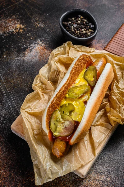 Hot dog kolbásszal egy faaprító asztalon. Közelről.. — Stock Fotó