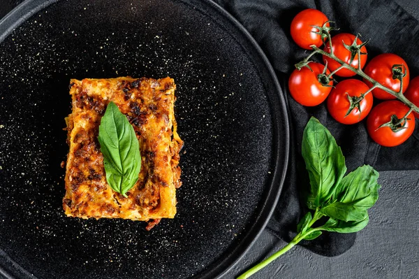 Piece of tasty hot lasagna. Traditional italian food. Black background. Top view — 스톡 사진