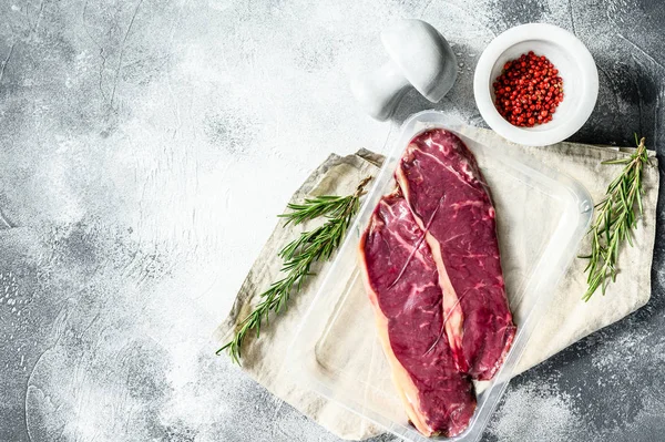 Carne fresca, carne de vacuno envasada al vacío, filete de Nueva York. Fondo oscuro. Embalaje del supermercado — Foto de Stock