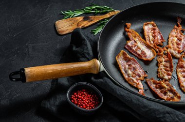 Kızarmış domuz pastırması dilimleri. Çiftlik organik eti. Siyah arka plan. Üst görünüm