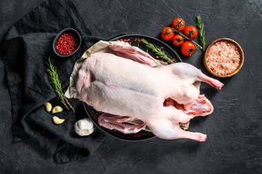 Çiğ ördek, pembe biber ve biberiye. Siyah arka plan. Üst görünüm