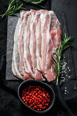 Kaya kesme tahtasındaki pastırma dilimleri. Domuz eti. Siyah arka plan. Üst görünüm