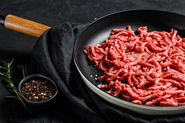 Kızartma tavasında kıyma. Çiftlik organik eti. Siyah arka plan. Üst görünüm
