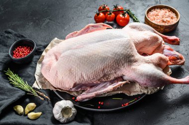 Tüm ördeği pembe biber ve biberiyeyle pişirmenin tarifi. Siyah arka plan. Üst Manzara. Metin için boşluk