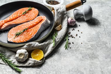 Tavada çiğ alabalık bifteği. Sağlıklı deniz ürünleri. Gri arka plan. Üst Manzara. Metin için boşluk