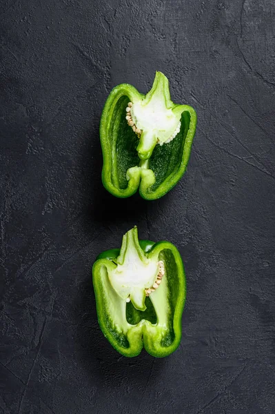 Snijd groene zoete peper, twee helften. Zwarte achtergrond. Bovenaanzicht. Ruimte voor tekst. — Stockfoto