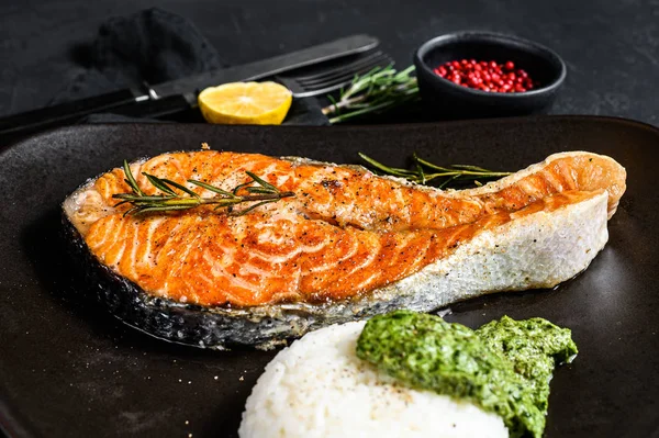 Grilled trout steak garnished with rice and spinach. Healthy seafood. Black background. Top view — 스톡 사진