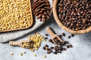 Çiğ çam fıstığı soyulmuş ve kabuğu soyulmuş. Gri arka plan. Üst görünüm