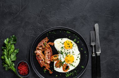 Pastırmalı sahanda yumurta. Siyah arka plan. Üst Manzara. Metin için boşluk