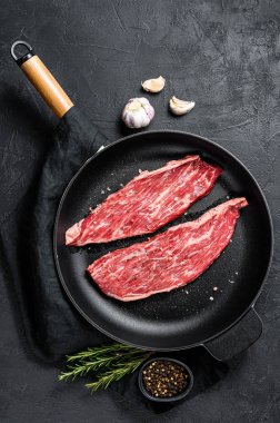 Tavada çiğ biftek var. Siyah mermer Angus eti. Siyah arka plan. Üst Manzara. Metin için boşluk