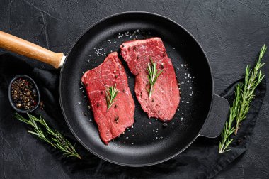 Tavada çiğ sığır filetosu. Et eti. Siyah arka plan. Üst görünüm
