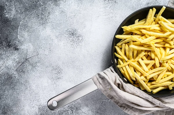 French fries in a frying pan. Gray background. Top view. Space for text — Stock Photo, Image