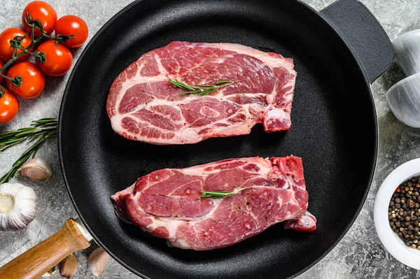 Bife cru de porco numa frigideira. Carne de quinta marmorizada. Fundo cinzento. Vista superior — Fotografia de Stock