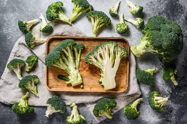 Raw broccoli halves in a wooden bowl. Gray background. Top view. — Stock Photo, Image