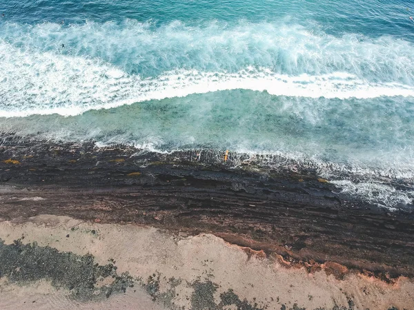 Vista aérea de los surfistas en las olas del océano Atlántico. Playa de arena. Panorama plano de fondo de un dron. Enfoque selectivo — Foto de stock gratuita