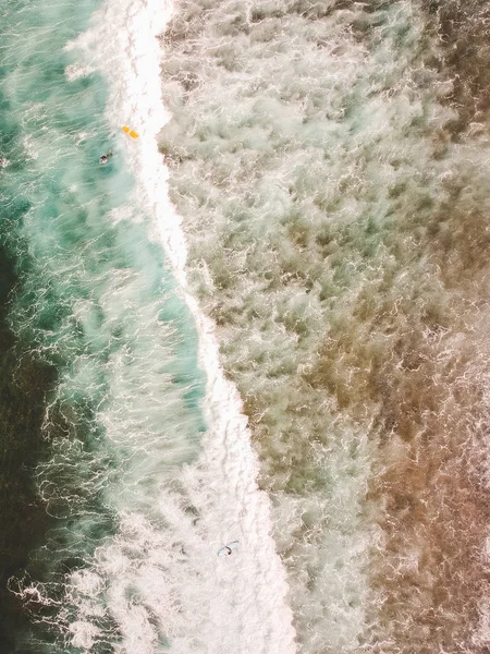 Veduta aerea dei surfisti sulle onde dell'Oceano Atlantico. Spiaggia di sabbia. Panorama girato su un drone. Focus sulla selettività — Foto stock gratuita