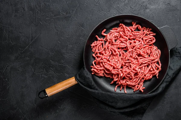 Raw minced pork in a frying pan. Black background. Top view. Space for text — 스톡 사진