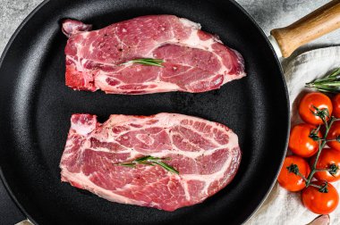 Kızartma tavasında çiğ biftek. Mermer çiftlik eti. Gri arka plan. Üst görünüm