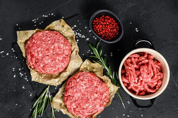Roh Hackfleisch Burger Steak Schnitzel und Gewürze. Biofleisch vom Bauernhof. schwarzer Hintergrund. Ansicht von oben — Stockfoto
