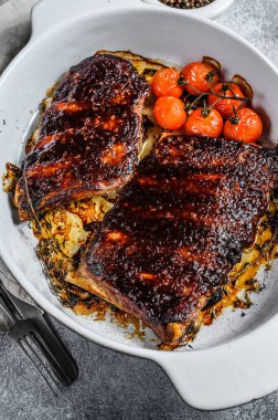 Pişirme kabında ızgara domuz pirzolası. Izgara et. Gri arka plan. Üst görünüm